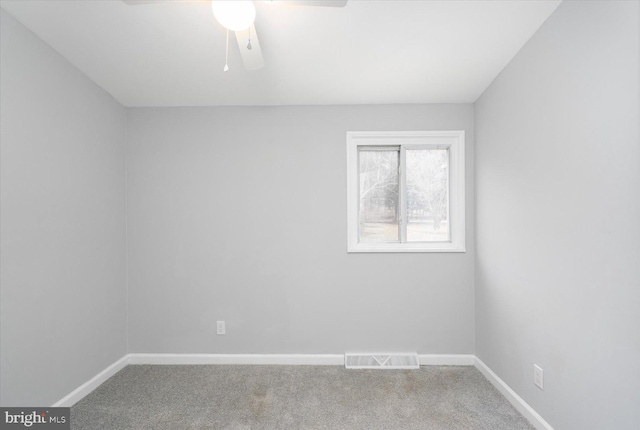 carpeted spare room with ceiling fan, visible vents, and baseboards