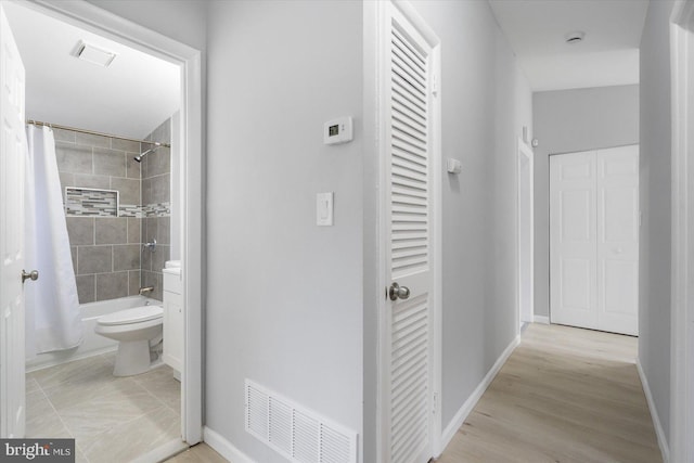 corridor featuring visible vents and baseboards