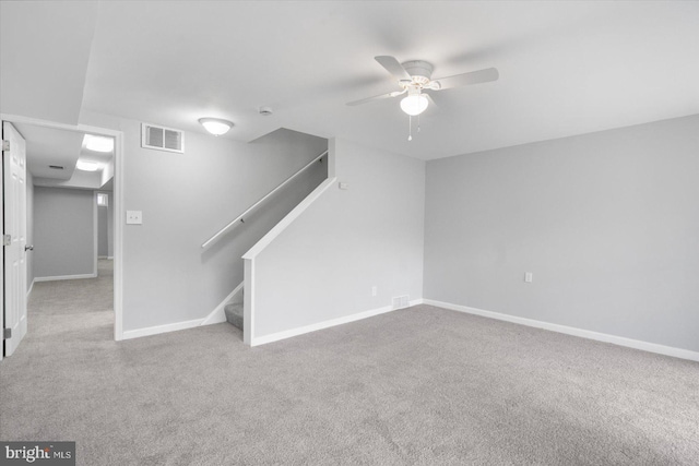 interior space featuring visible vents, stairway, a ceiling fan, carpet flooring, and baseboards