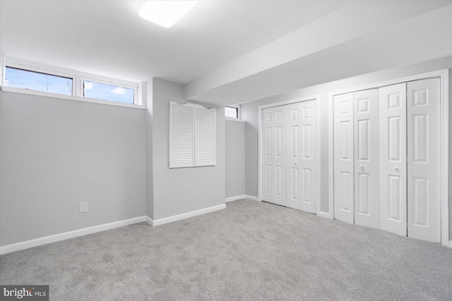 basement featuring carpet flooring and baseboards