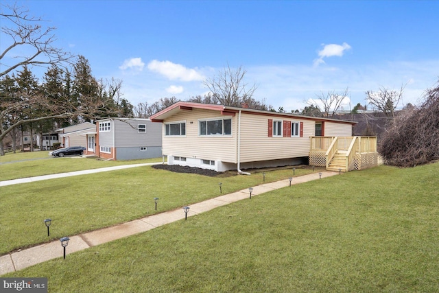 manufactured / mobile home with a front lawn and a wooden deck