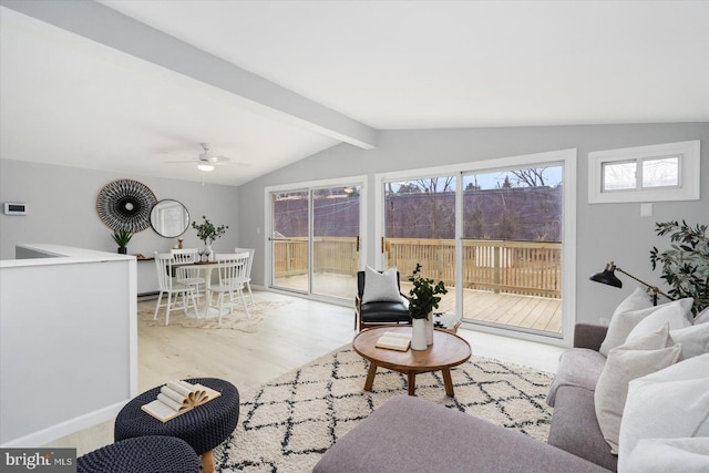 living area featuring lofted ceiling with beams, ceiling fan, baseboards, and wood finished floors