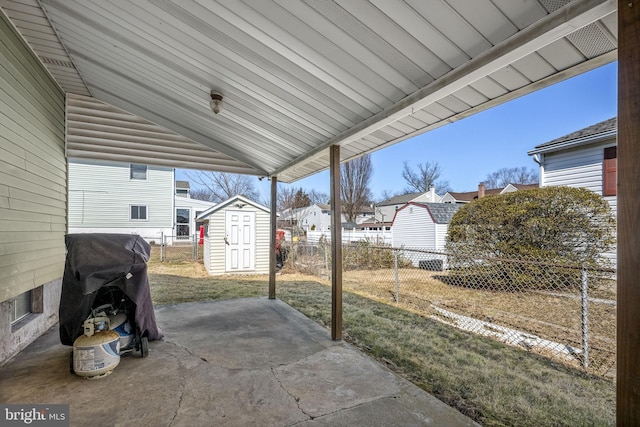 view of patio with an outdoor structure, fence, area for grilling, and a shed