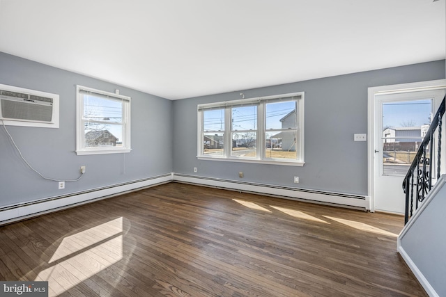 unfurnished living room featuring baseboards, wood finished floors, a wall mounted air conditioner, stairs, and a baseboard heating unit