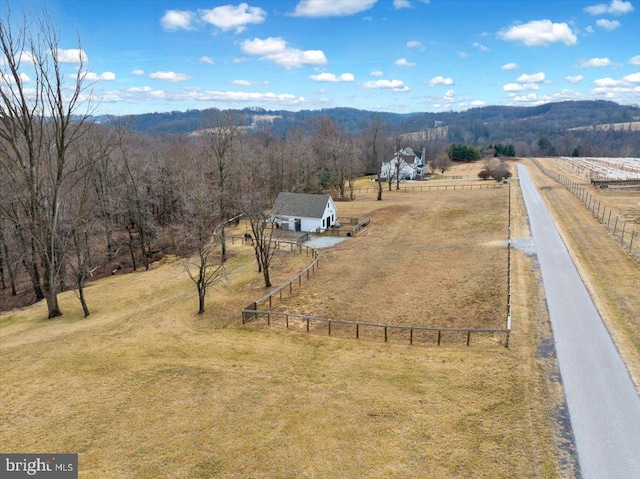 birds eye view of property featuring a rural view, a wooded view, and a mountain view