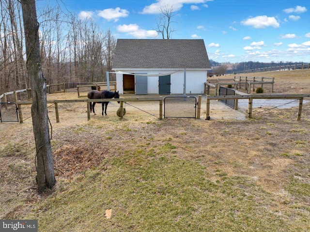 exterior space with a gate, a rural view, and an outdoor structure