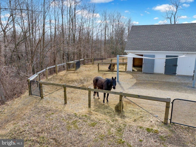 view of yard with an outbuilding, a gate, and a rural view