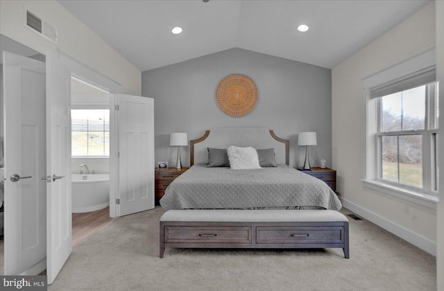 bedroom with vaulted ceiling, light colored carpet, visible vents, and baseboards