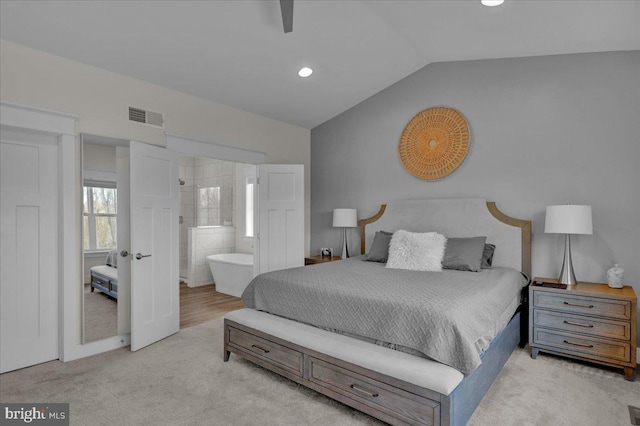 bedroom featuring carpet, visible vents, vaulted ceiling, and ensuite bathroom