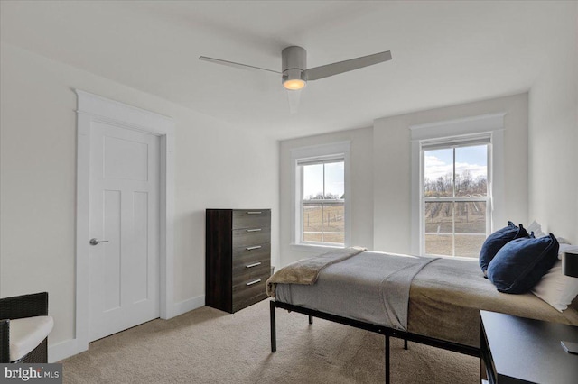 carpeted bedroom featuring ceiling fan and baseboards