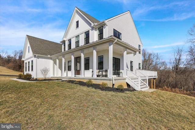 view of front of home with roof with shingles, a porch, board and batten siding, and a front yard