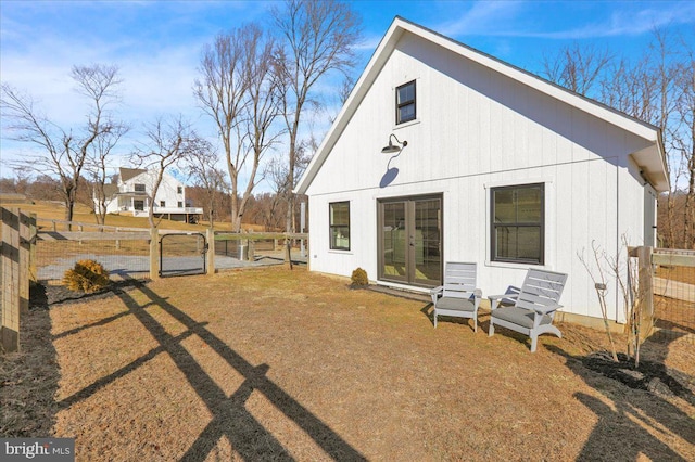 rear view of property featuring fence and french doors