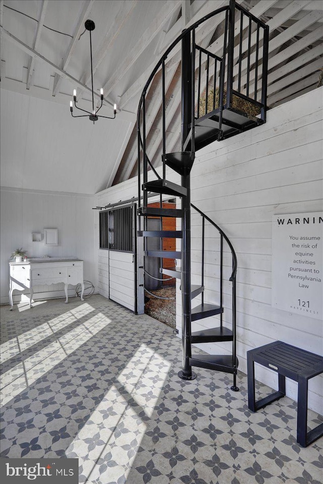 interior space featuring a chandelier, wooden walls, vaulted ceiling, and tile patterned floors