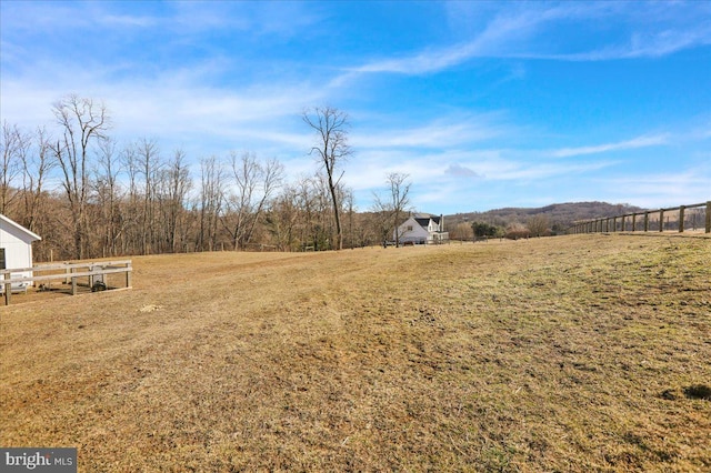 view of yard featuring fence and a rural view