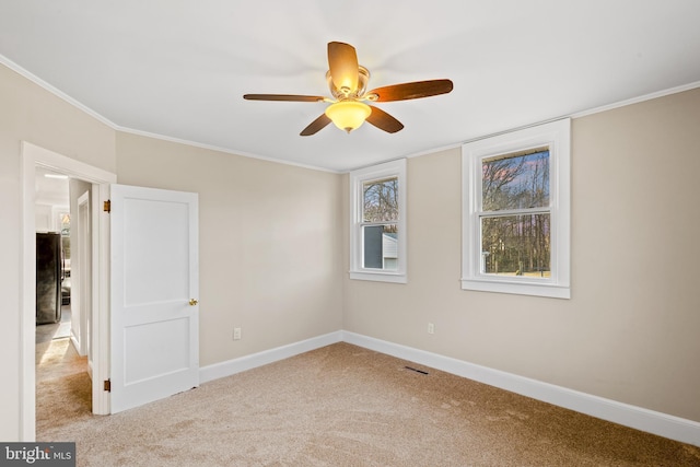 unfurnished room featuring ceiling fan, baseboards, carpet floors, and ornamental molding