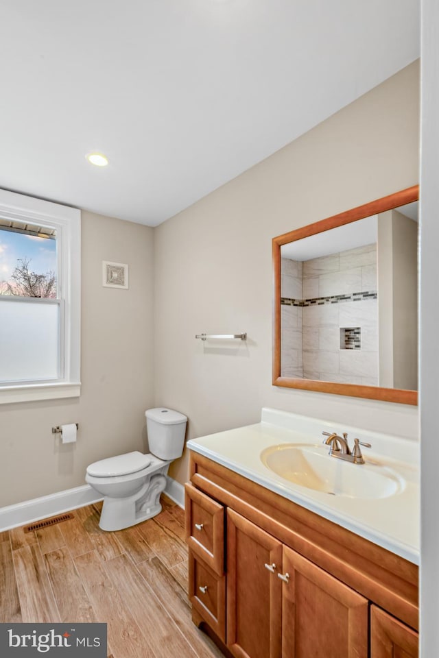 full bathroom featuring visible vents, toilet, wood finished floors, baseboards, and vanity