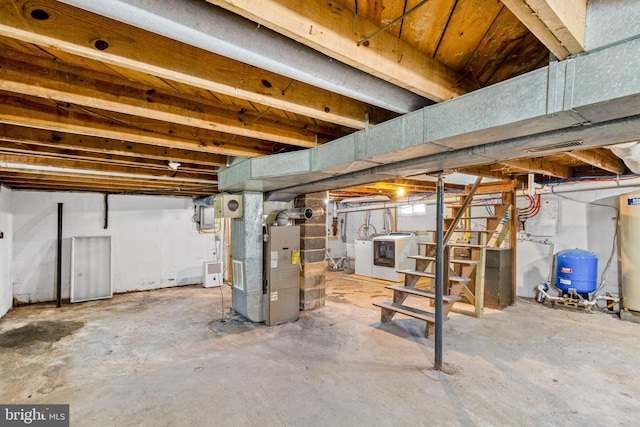 unfinished below grade area featuring gas water heater, stairway, and heating unit