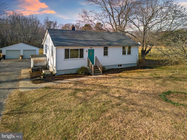 view of front of property with an outbuilding, entry steps, a front yard, a garage, and a chimney