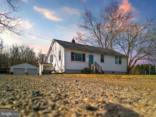 view of front of home with entry steps, an outbuilding, and a garage