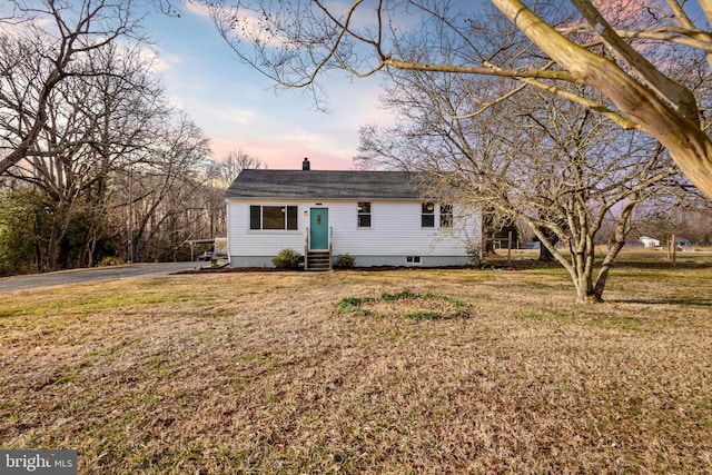 ranch-style home featuring driveway, a lawn, a chimney, and entry steps