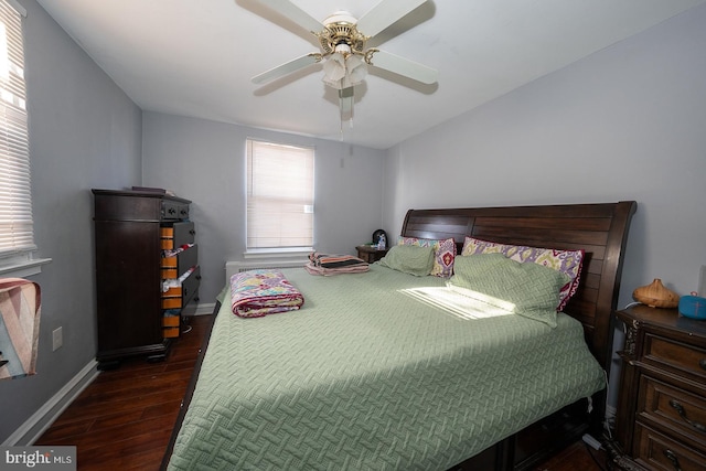 bedroom with dark wood-style floors, baseboards, and a ceiling fan