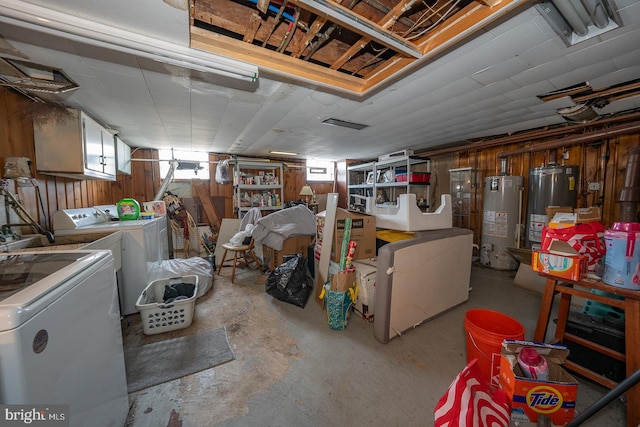 basement with water heater, separate washer and dryer, and wooden walls