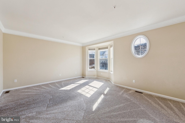 carpeted empty room with visible vents, crown molding, and baseboards