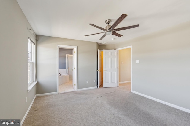 unfurnished bedroom with ensuite bath, a ceiling fan, baseboards, and carpet floors