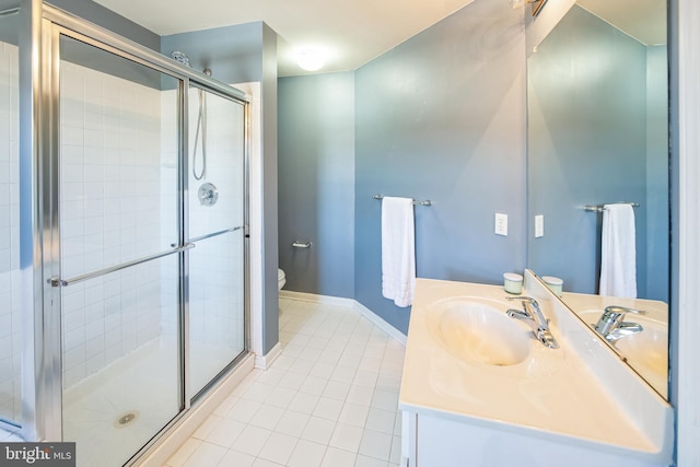 full bath featuring toilet, a stall shower, tile patterned flooring, baseboards, and vanity