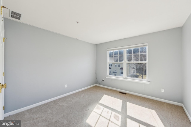 carpeted empty room featuring visible vents and baseboards