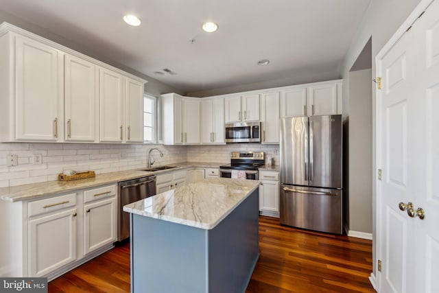 kitchen with dark wood-style floors, white cabinets, appliances with stainless steel finishes, and a sink