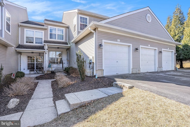 view of front of property with a porch, a garage, and aphalt driveway