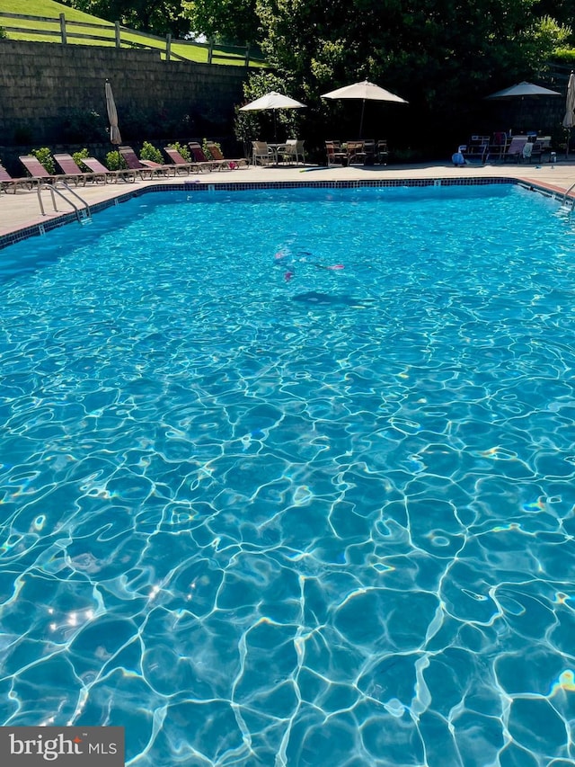 community pool featuring a patio and fence