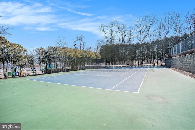 view of tennis court with playground community and fence