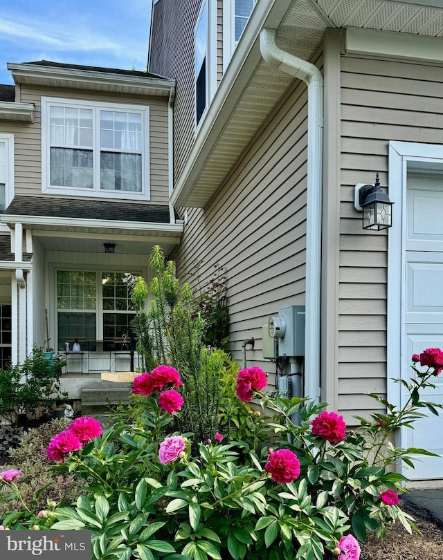 view of side of property with an attached garage and covered porch