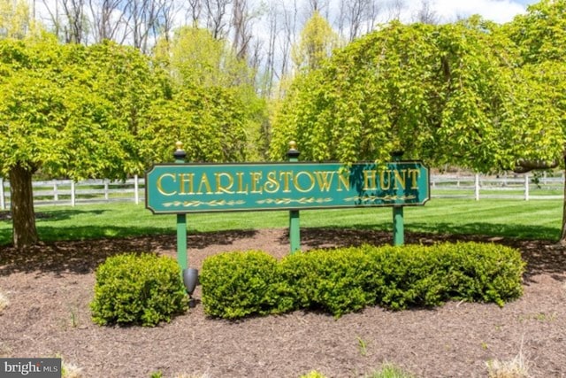 community / neighborhood sign featuring fence