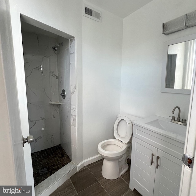 full bath with toilet, vanity, visible vents, baseboards, and a marble finish shower