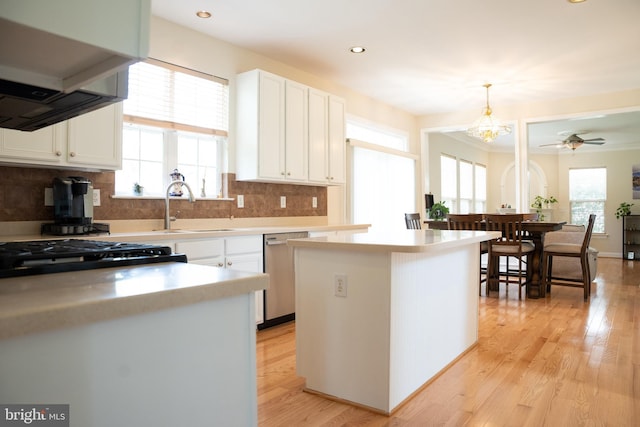 kitchen featuring dishwasher, light wood-style flooring, a wealth of natural light, and a sink