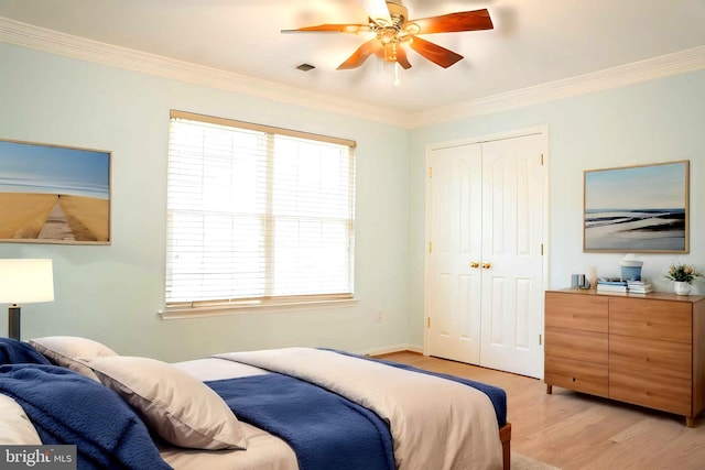 bedroom featuring a closet, visible vents, light wood-type flooring, and ornamental molding