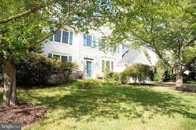 colonial house featuring a front lawn