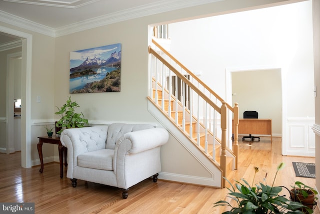 sitting room featuring wood finished floors, stairs, baseboards, and ornamental molding