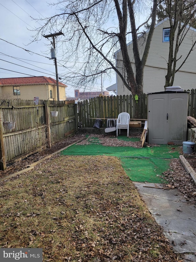 view of yard with a storage shed, an outdoor structure, and a fenced backyard