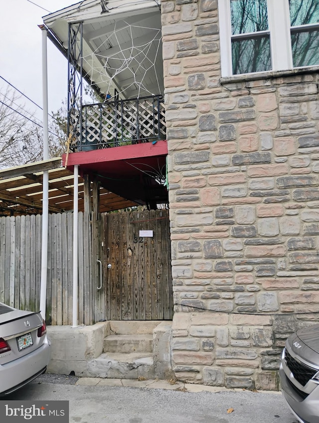 exterior space with stone siding and fence