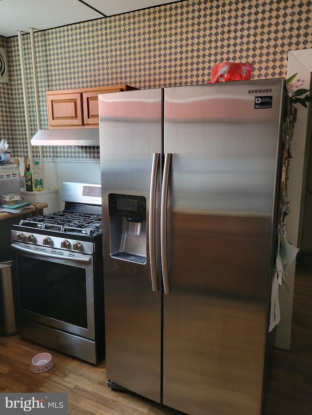 kitchen featuring wallpapered walls, appliances with stainless steel finishes, and wood finished floors