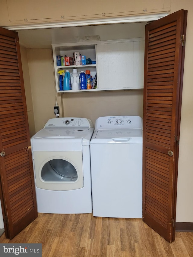 laundry area with light wood finished floors, laundry area, and washer and clothes dryer