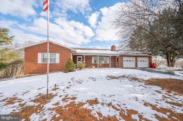 ranch-style home with a garage, driveway, brick siding, and a chimney