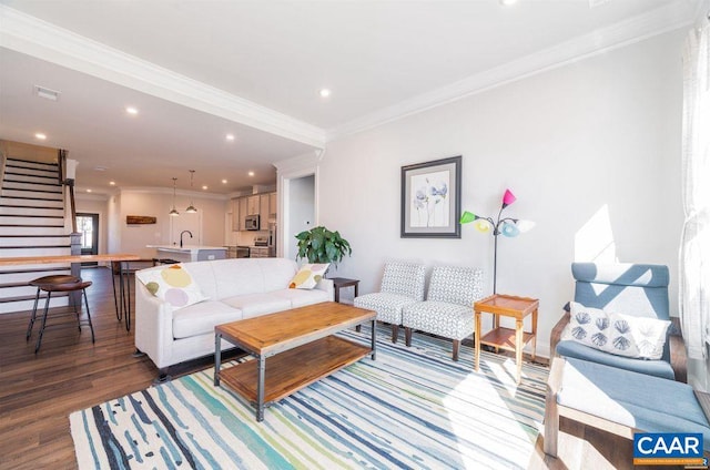 living area featuring recessed lighting, visible vents, ornamental molding, wood finished floors, and stairs