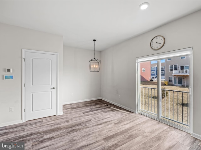 unfurnished dining area with baseboards, a chandelier, wood finished floors, and recessed lighting