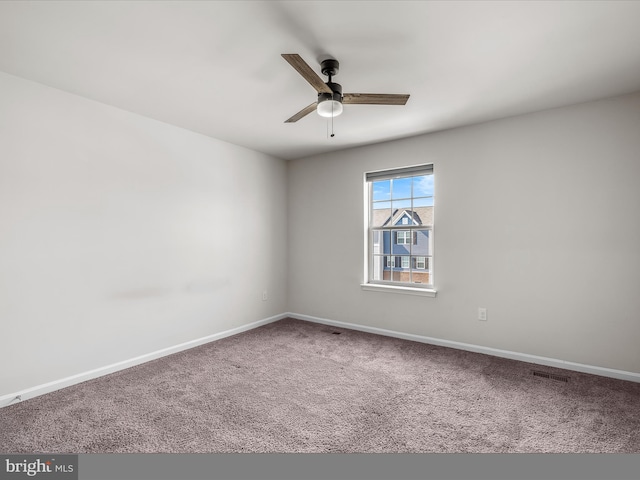 spare room with a ceiling fan, carpet, visible vents, and baseboards