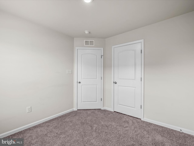 unfurnished bedroom featuring carpet, visible vents, and baseboards